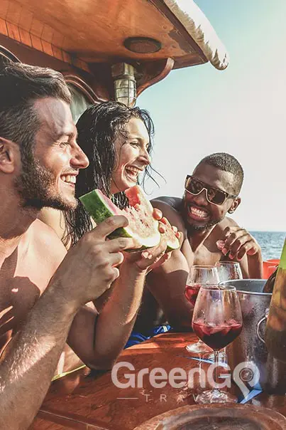 Man eating watermelon on Galapagos Cruise and group drinking sangria