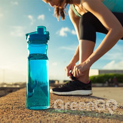 Girl tying her shoe next to a reusable water bottle