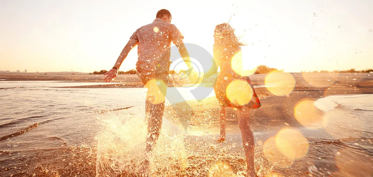 Galapagos-honeymoon-Couple-running-through-the-ocean-holding-hands-during-sunset