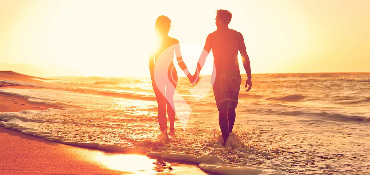 Tip-Top-V-Galapagos-Cruise-Honeymoon-Experience-Couple-on-Beach-Holding-hands-during-sunset